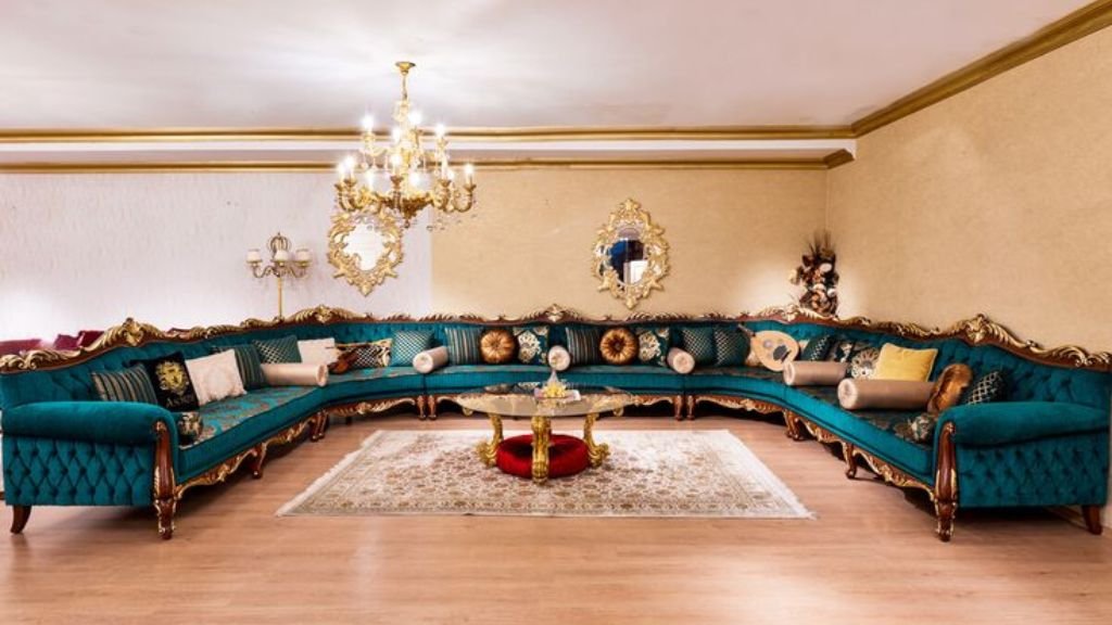 Extravagant teal blue L-shaped sectional couch with Victorian gold-leaf woodwork in a grand hall