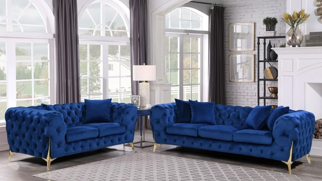 A royal blue velvet Chesterfield sofa set with gold legs in a bright, modern living room.