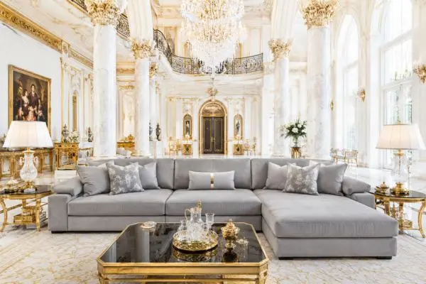 Well-maintained grey sofa in a bright and royal mansion setting.