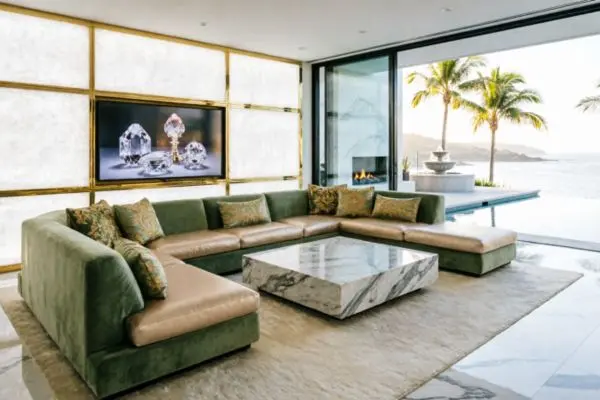 Ultra luxury mansion living room opening to a beachfront infinity pool with palm trees