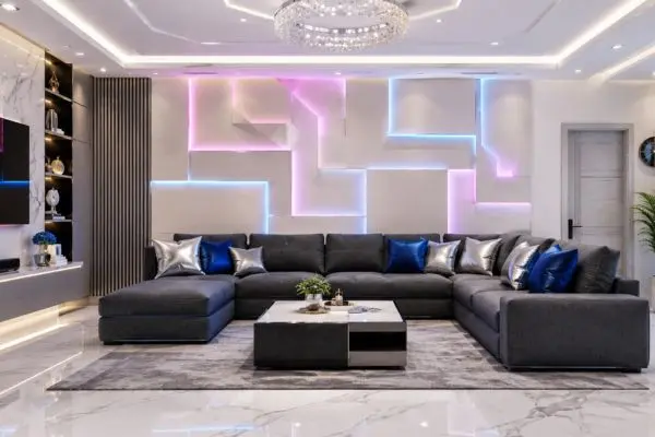 Deep charcoal gray modular sectional sofa with pink and blue neon LED strip wall lighting.