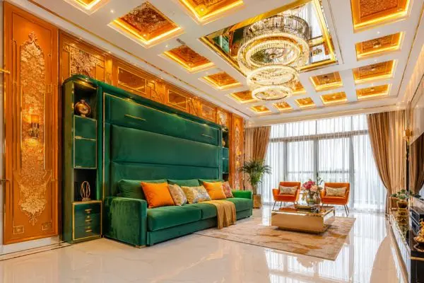 Emerald green Murphy bed sofa in a bright luxury room with golden orange wall panels.
