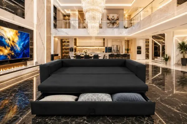 Modern black velvet sleeper sofa with open storage drawer in a bright luxury villa.