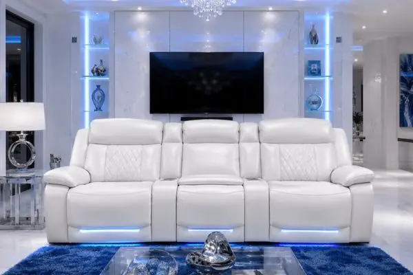 A clean three-seater couch with blue under-glow lighting placed on a fuzzy dark blue rug.