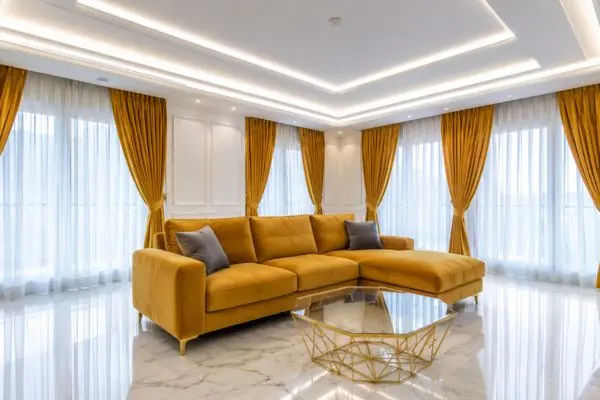 Mustard yellow velvet small sectional sofa in a luxury living room.
