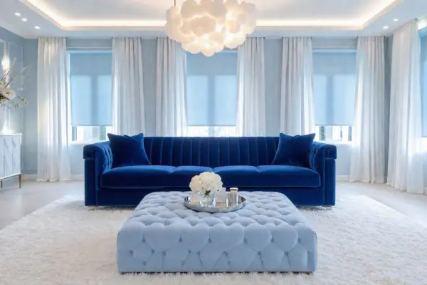 A luxury vibrant front-facing elegant couch centered in a modern bright ice-blue and white styled living room.