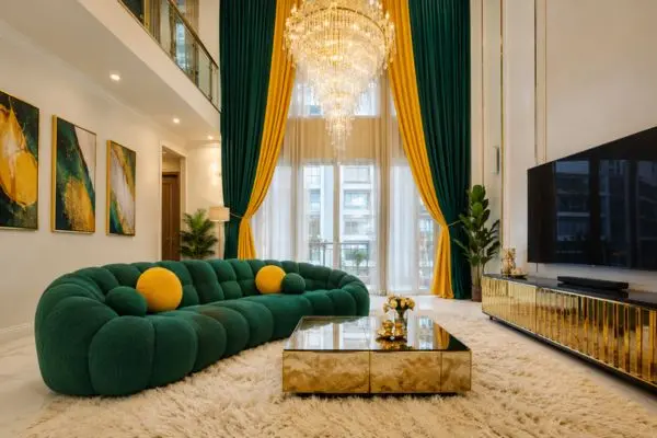Emerald green bubble sofa with round yellow pillows in a luxury high ceiling living room