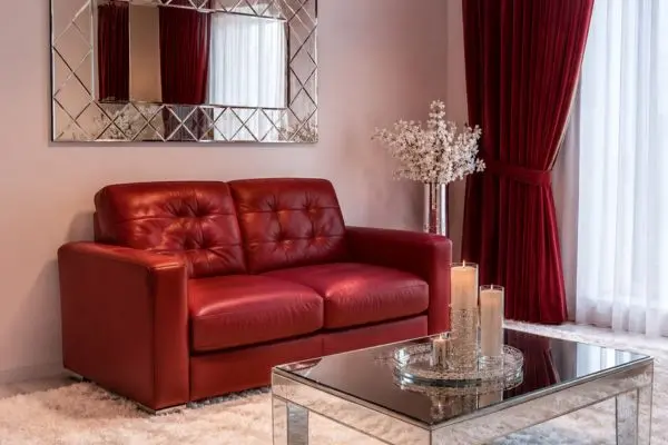 A compact red seating unit placed in a modern luxurious white and red living room setup.