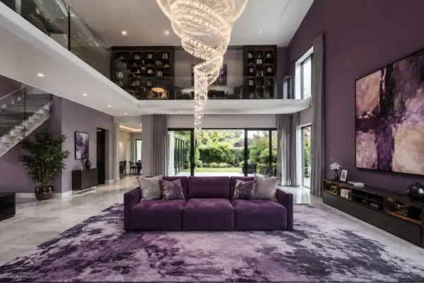 A deep purple velvet small modular sofa with three visible block sections in a luxury duplex living room.