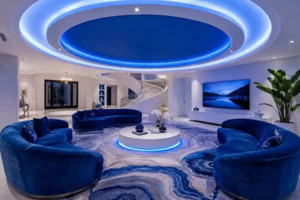 Multiple curved royal blue velvet sofas in a modern luxury open-space living room.