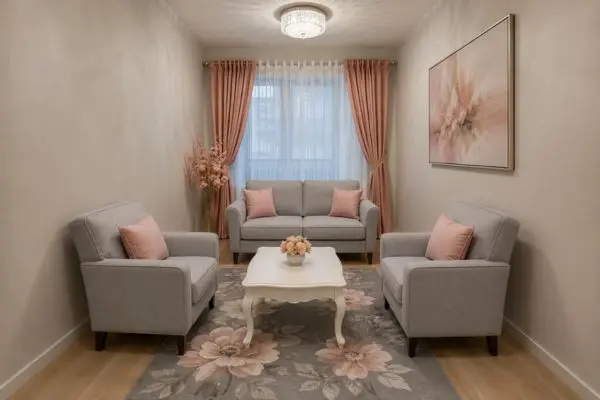 Three pieces of compact grey fabric couches with soft peach cushions in a narrow living room.
