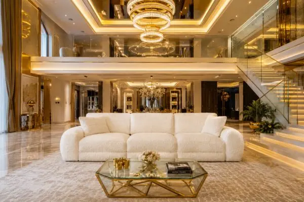 A luxury cream three-seater seating option in a bright golden modern villa interior