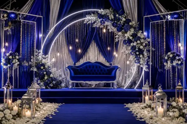 Royal blue velvet wedding loveseat sofa on a modern silver and blue stage backdrop.